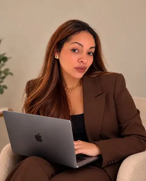 Alby Zelaya con traje café y su laptop